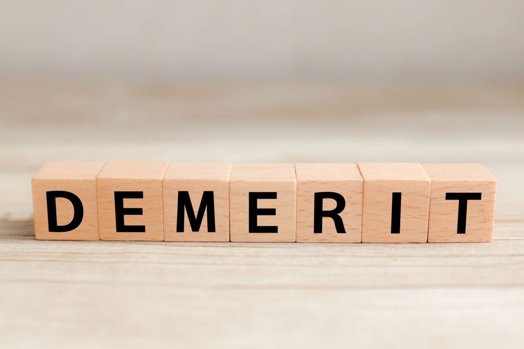 「DEMERIT」の文字が書かれたキューブの画像